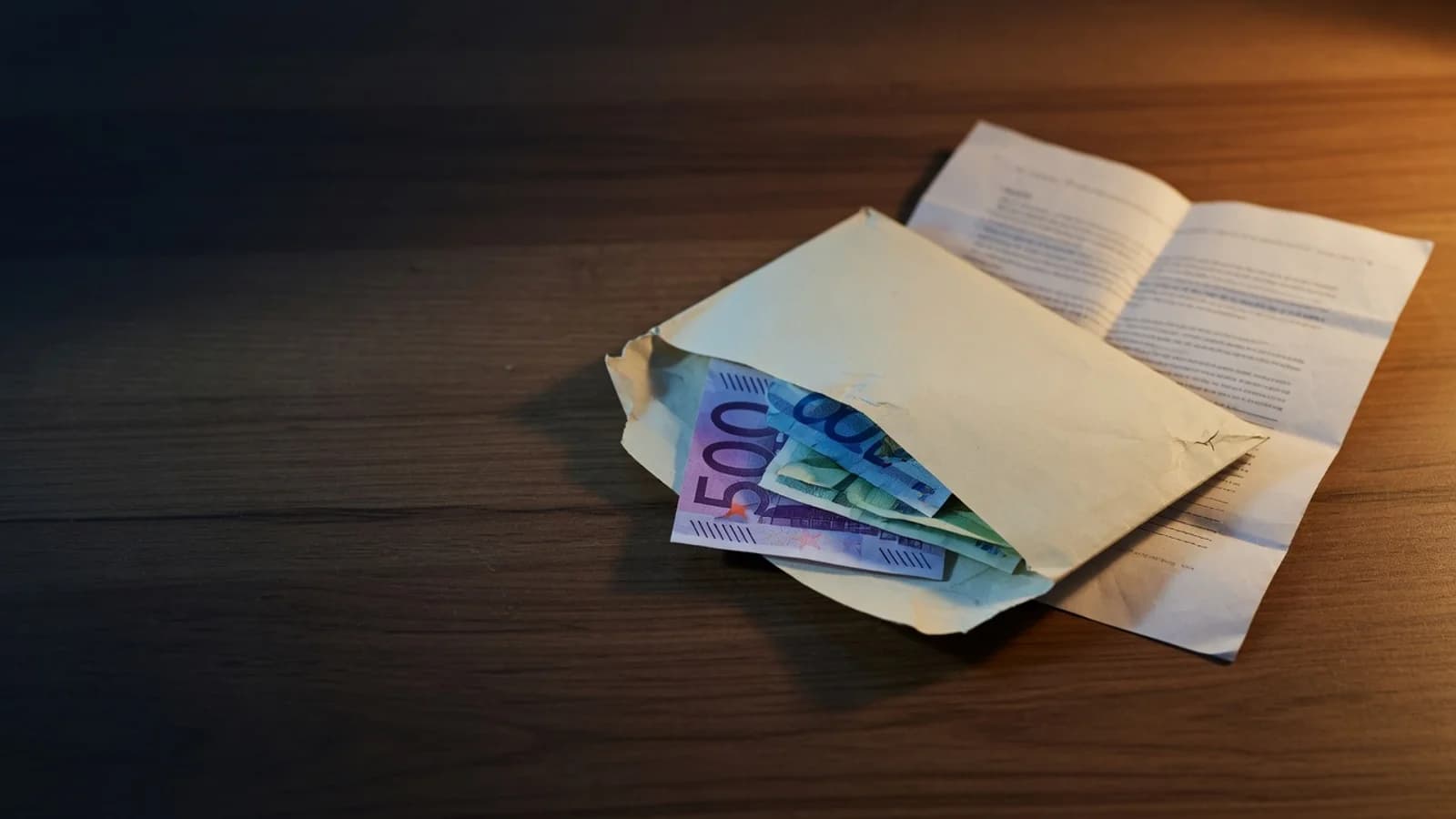 Sobre con billetes de euro y un documento