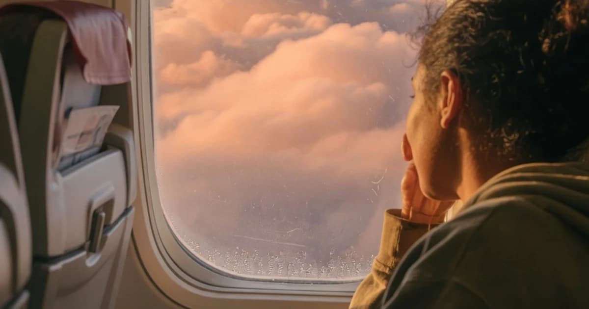 Persona mirando por la ventanilla del avión de regreso a España